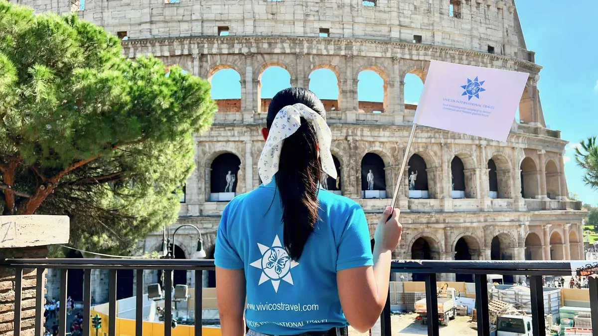 Guide with a headset explaining the arena floor and underground levels of the Colosseum to a group in Rome